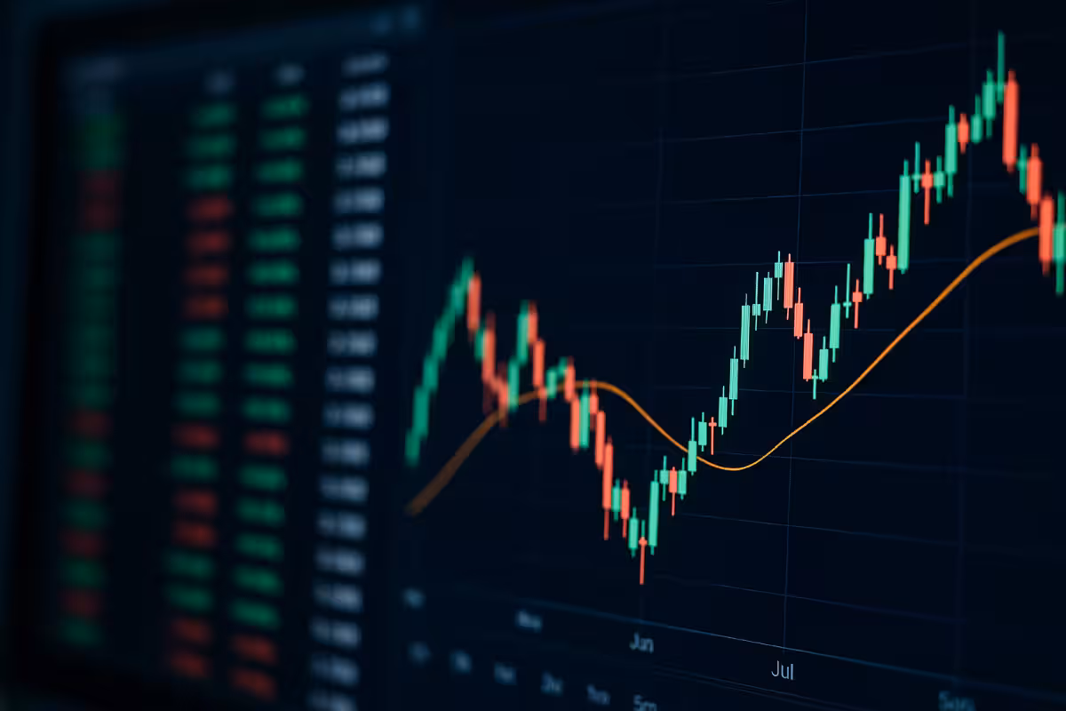 Close-up of a computer screen showing colorful candlestick charts, moving averages, and financial data tables, symbolizing key signals retail traders should watch for.